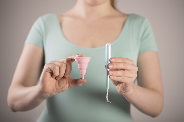 žena držící tampon a menstruační kalíšek
